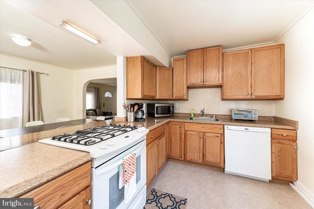 kitchen featuring white appliances, ornamental molding, sink, and tasteful backsplash