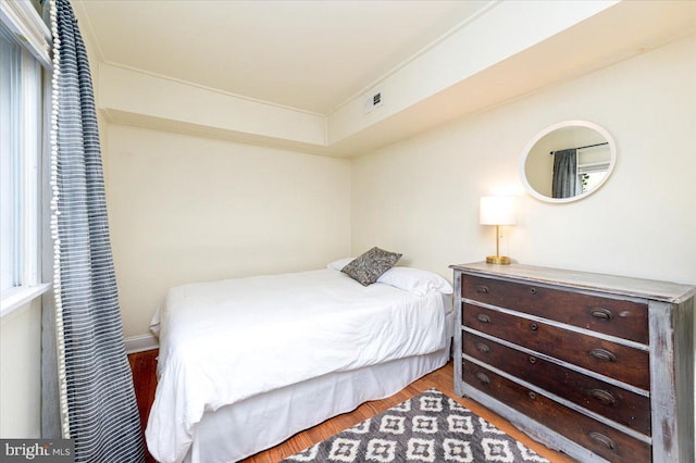 bedroom featuring multiple windows and hardwood / wood-style flooring