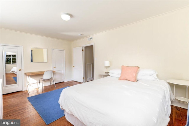 bedroom with dark hardwood / wood-style floors