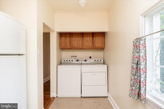 laundry area with washer and clothes dryer, cabinets, light wood-type flooring, and washer hookup