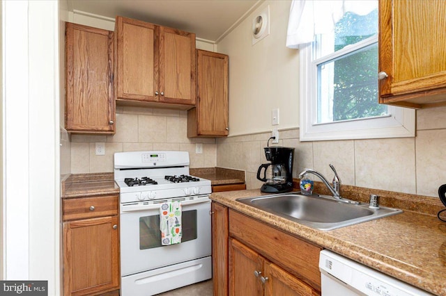 kitchen with white appliances, sink, and tasteful backsplash