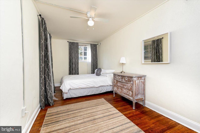 bedroom featuring ceiling fan, ornamental molding, and dark wood-type flooring