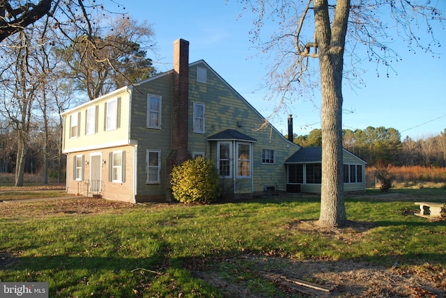 rear view of house featuring a yard