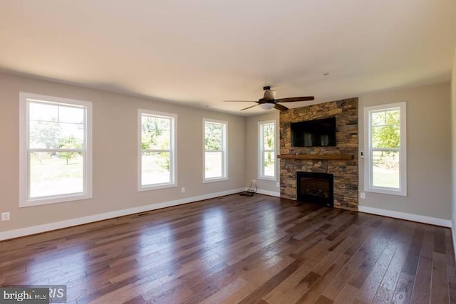 unfurnished living room with plenty of natural light, dark hardwood / wood-style floors, ceiling fan, and a fireplace