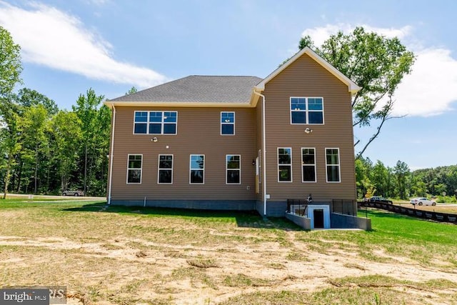 rear view of house featuring a yard