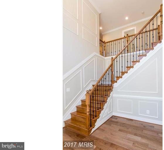 staircase featuring crown molding and light wood-type flooring