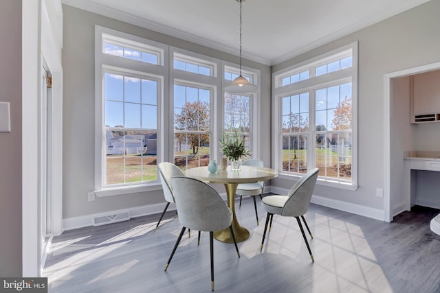 dining area featuring light hardwood / wood-style flooring and crown molding