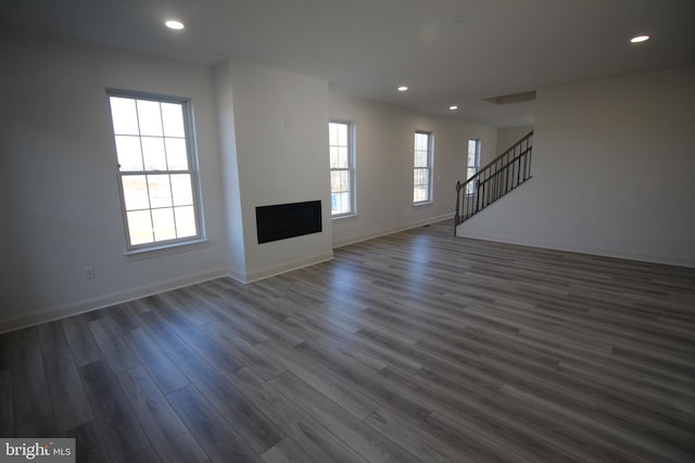 unfurnished living room with plenty of natural light and dark wood-type flooring