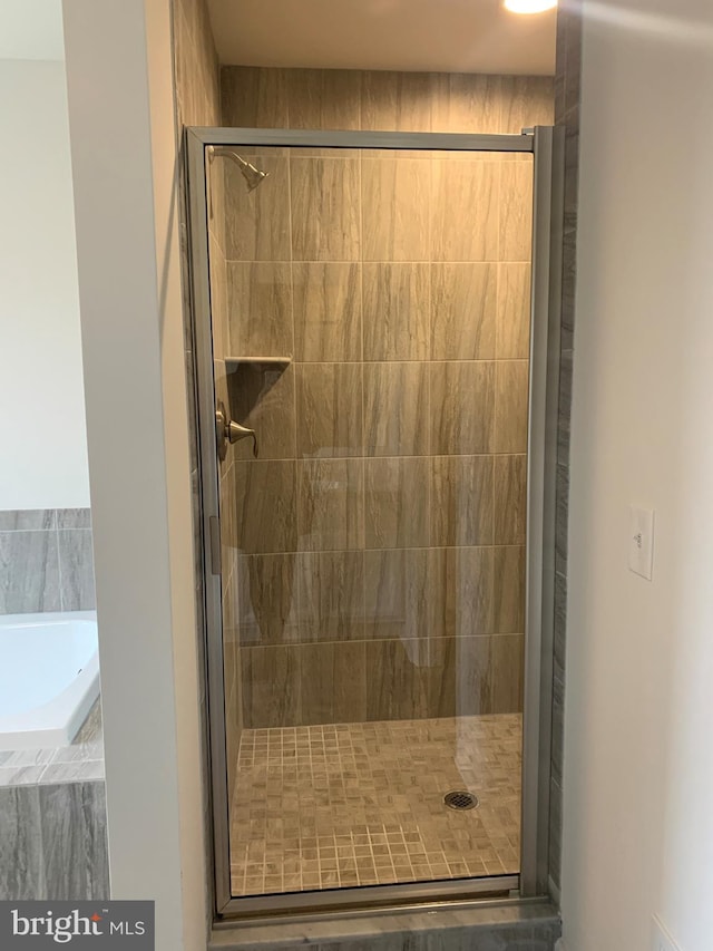 bathroom featuring separate shower and tub