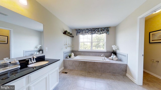 bathroom featuring a relaxing tiled bath, vanity, and tile floors