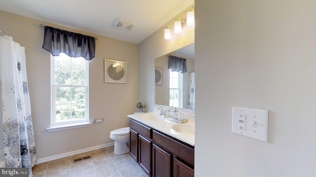 bathroom with toilet, dual bowl vanity, and tile floors