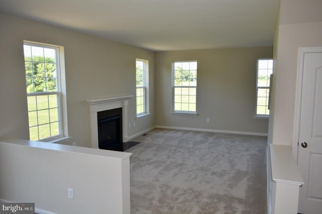 unfurnished living room with a wealth of natural light and light colored carpet