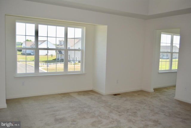 empty room with plenty of natural light and light carpet