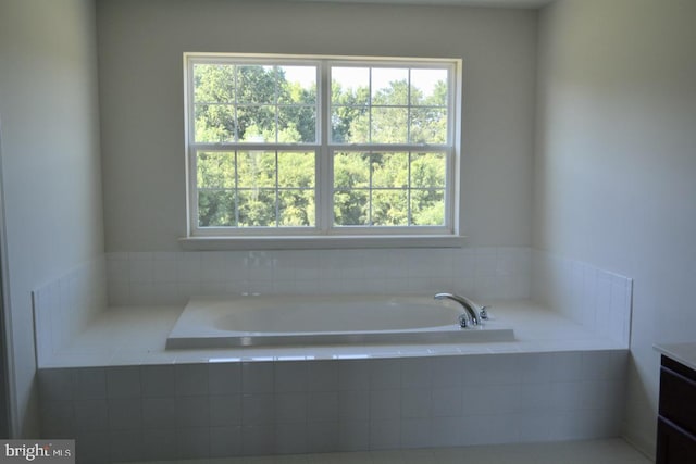 bathroom with plenty of natural light and tiled bath