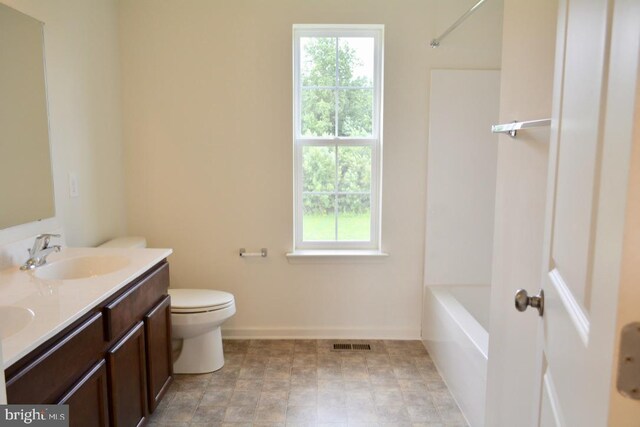 full bathroom featuring a healthy amount of sunlight, washtub / shower combination, tile floors, and toilet