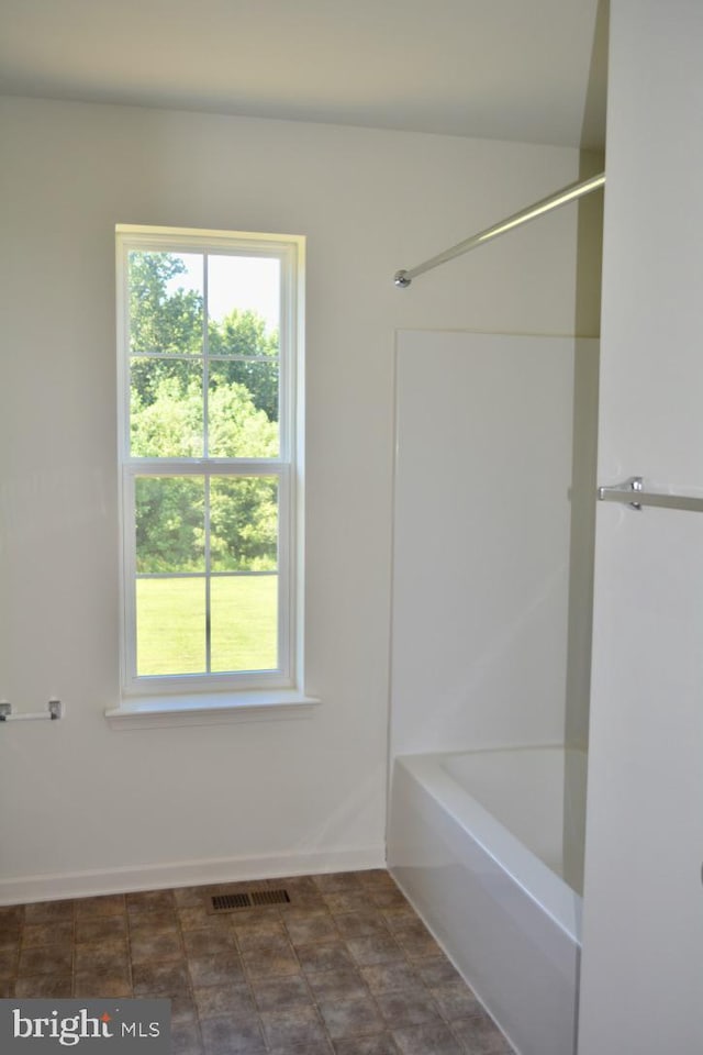 bathroom with tile flooring and bathtub / shower combination