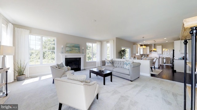 living room featuring light carpet and an inviting chandelier