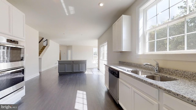 kitchen featuring white cabinets, light stone counters, dark wood-type flooring, and stainless steel appliances