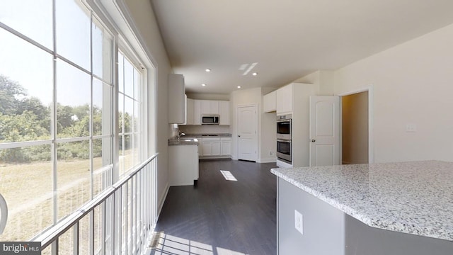 kitchen featuring light stone counters, stainless steel appliances, sink, dark hardwood / wood-style floors, and white cabinets