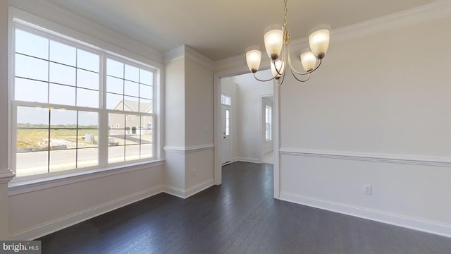 empty room with crown molding, dark wood-type flooring, and a chandelier