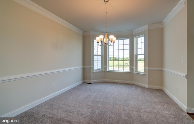 carpeted spare room with ornamental molding and a chandelier