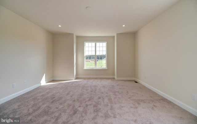 spare room featuring light colored carpet