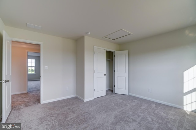 unfurnished bedroom featuring light carpet and a closet