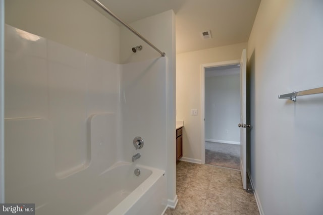 bathroom featuring vanity, tile floors, and bathing tub / shower combination