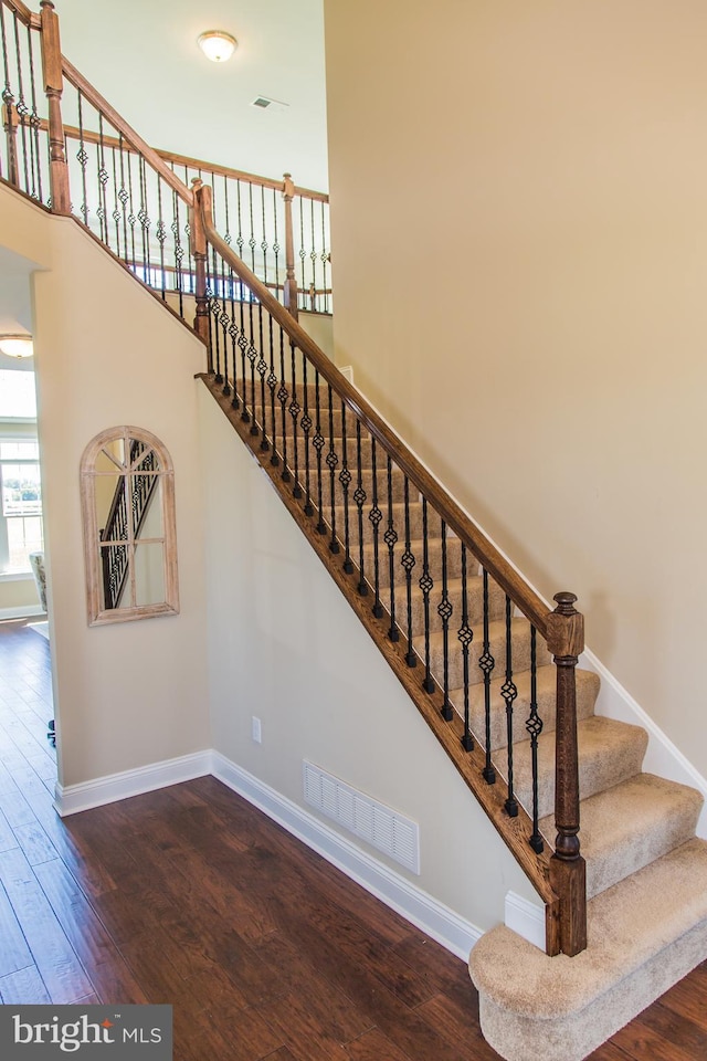 staircase with dark wood-type flooring