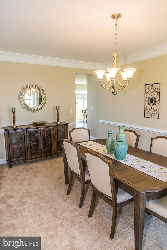 carpeted dining area featuring a chandelier and crown molding