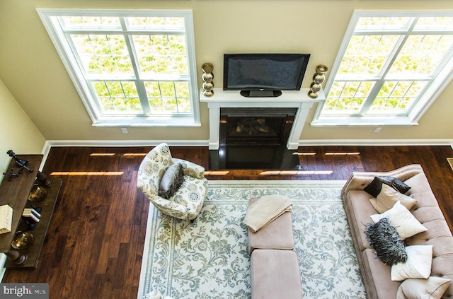 living room with dark wood-type flooring and a wealth of natural light