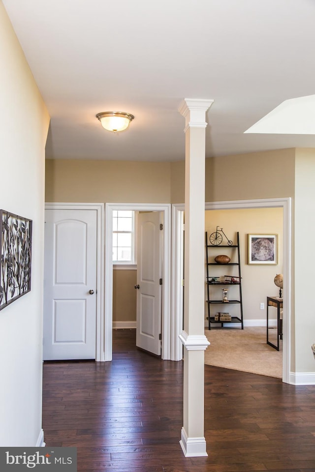 entryway with dark wood-type flooring and ornate columns