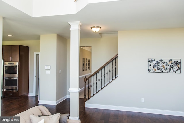 interior space with decorative columns and dark wood-type flooring