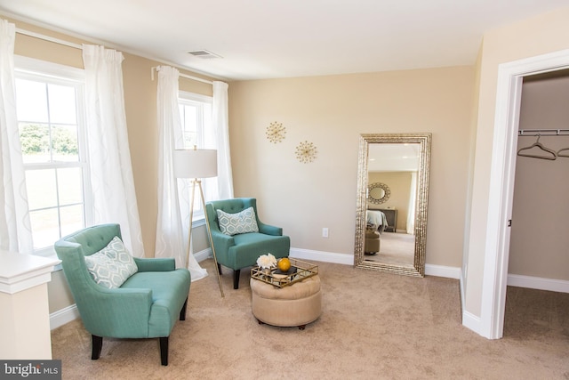 sitting room with plenty of natural light and light carpet