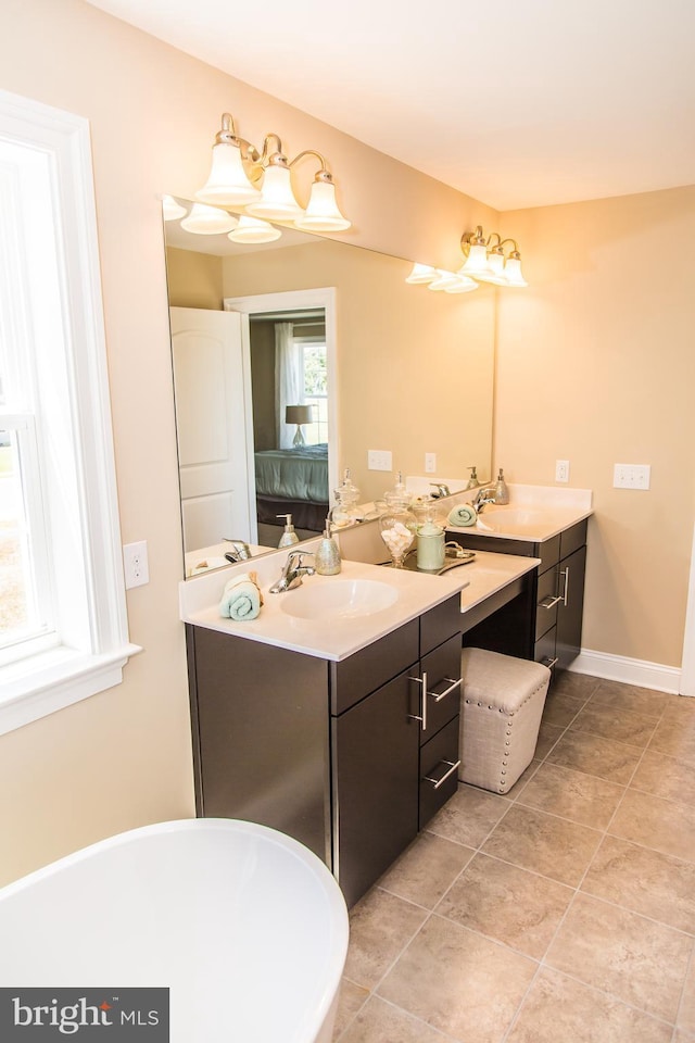 bathroom with a washtub, tile floors, and vanity