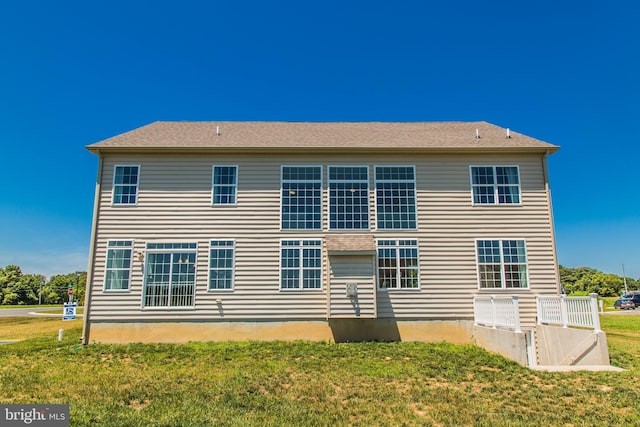 rear view of property with a yard