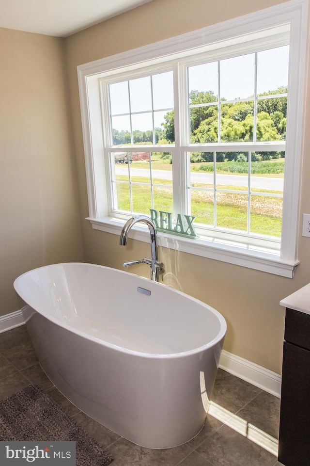 bathroom with plenty of natural light, tile floors, and vanity