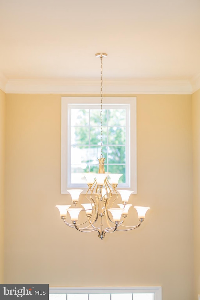 interior details with ornamental molding and a chandelier