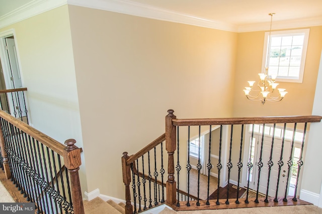 stairway with a notable chandelier, ornamental molding, and light carpet