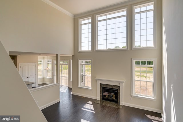 unfurnished living room featuring a fireplace, dark hardwood / wood-style floors, and a wealth of natural light