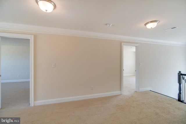 unfurnished room featuring ornamental molding and light colored carpet