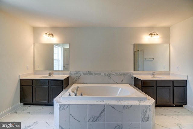 bathroom featuring double sink, large vanity, and tiled tub