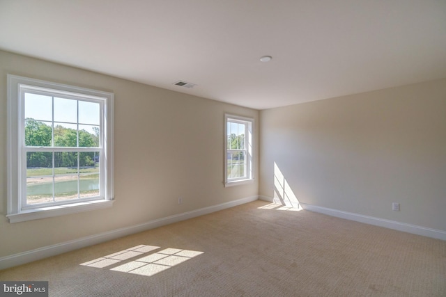 unfurnished room featuring light colored carpet