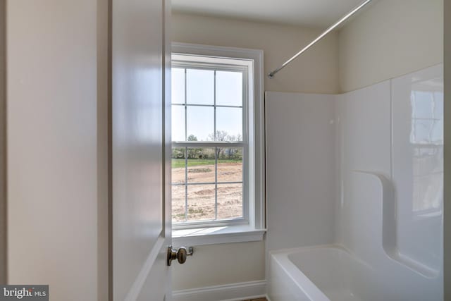 bathroom with a healthy amount of sunlight and bathing tub / shower combination