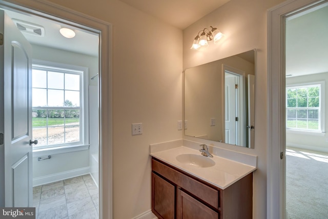 bathroom featuring tile flooring, vanity, and a wealth of natural light