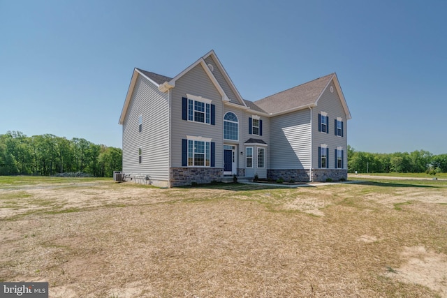 view of front of property with a front lawn and central air condition unit