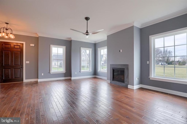 unfurnished living room with ornamental molding, dark wood-type flooring, and ceiling fan with notable chandelier