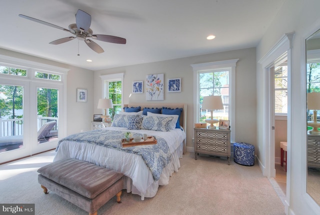 bedroom featuring light carpet, ceiling fan, access to outside, and multiple windows