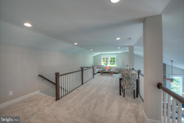 interior space with a wealth of natural light, light carpet, and vaulted ceiling