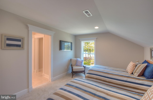 bedroom with light carpet and vaulted ceiling